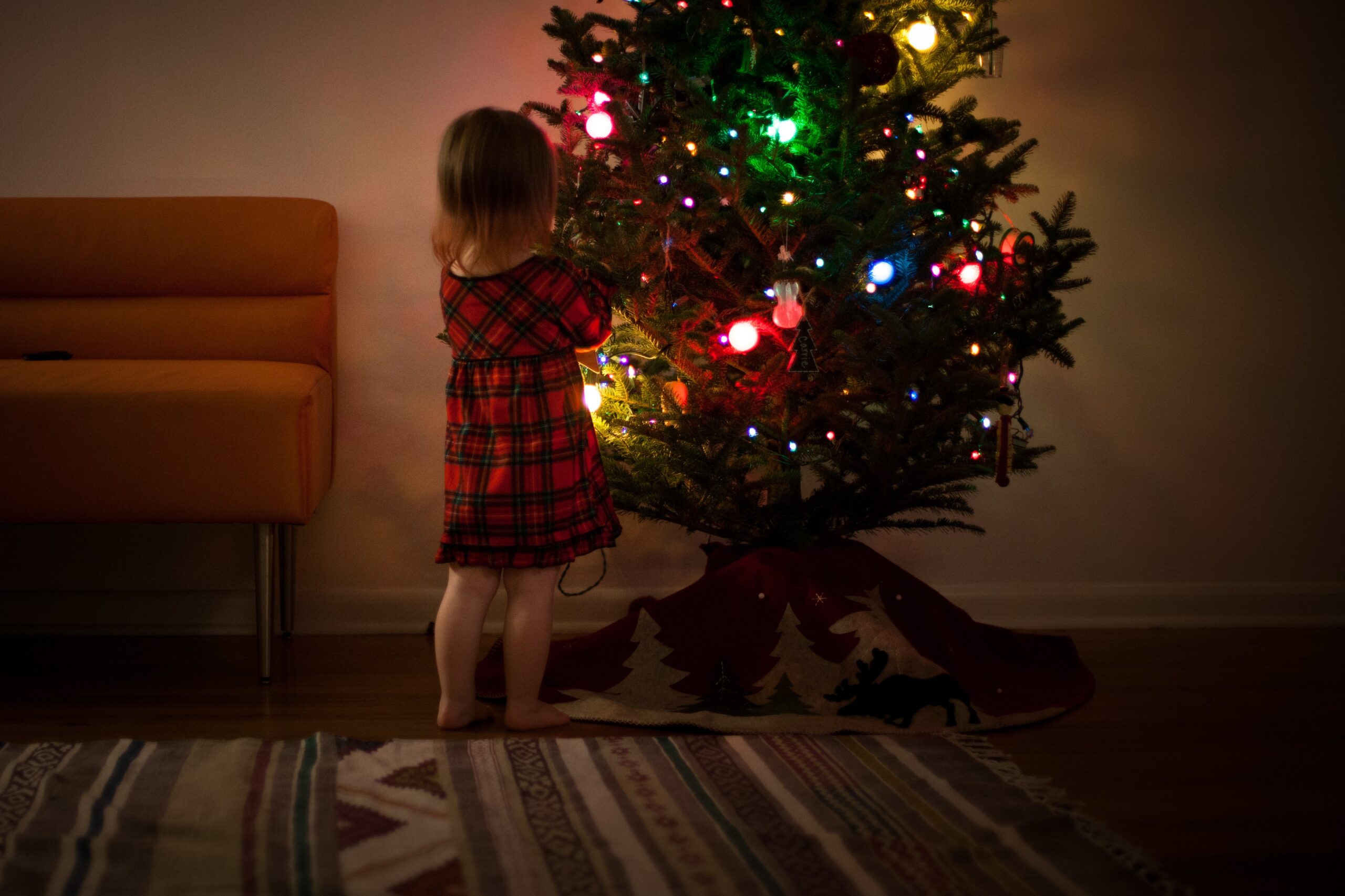 kid-tree-sing-at-home-mom-broadway-christmas-songs child at christmas tree